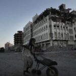 An elderly man walks past a damaged building in Aden, Yemen, in 2018.