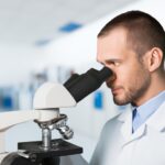 male scientist lookin in microscope